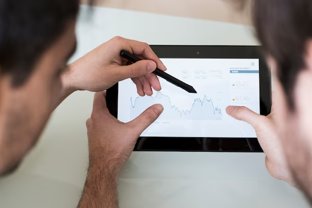 People hold a tablet in their hands and study the chart